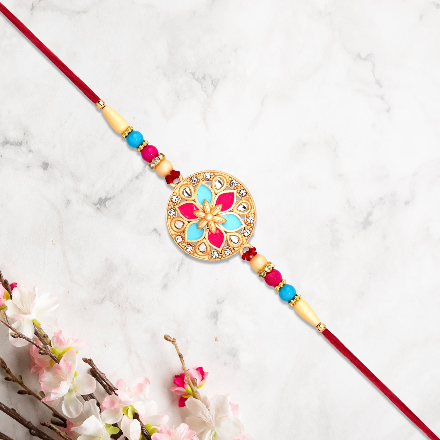 Round Floral Rakhi With Pink-blue Enamel And Beaded Thread Round Floral Rakhi With Pink-blue Enamel And Beaded Thread